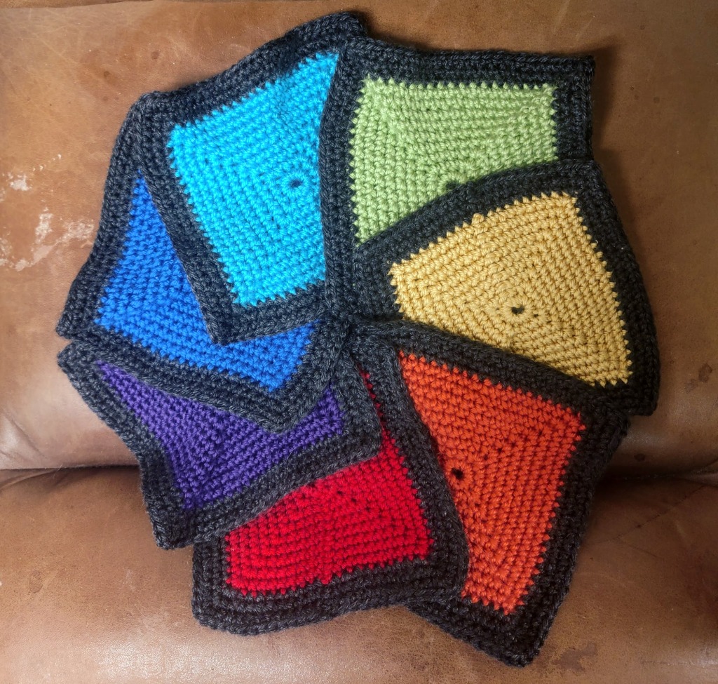 A spiral of crochet squares in different colors with black borders